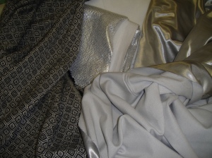 Materials for my winter coat (clockwise from left): fashion fabric, foil-backed underlining, plain underlining, Kasha lining right side, Kasha lining wrong side.